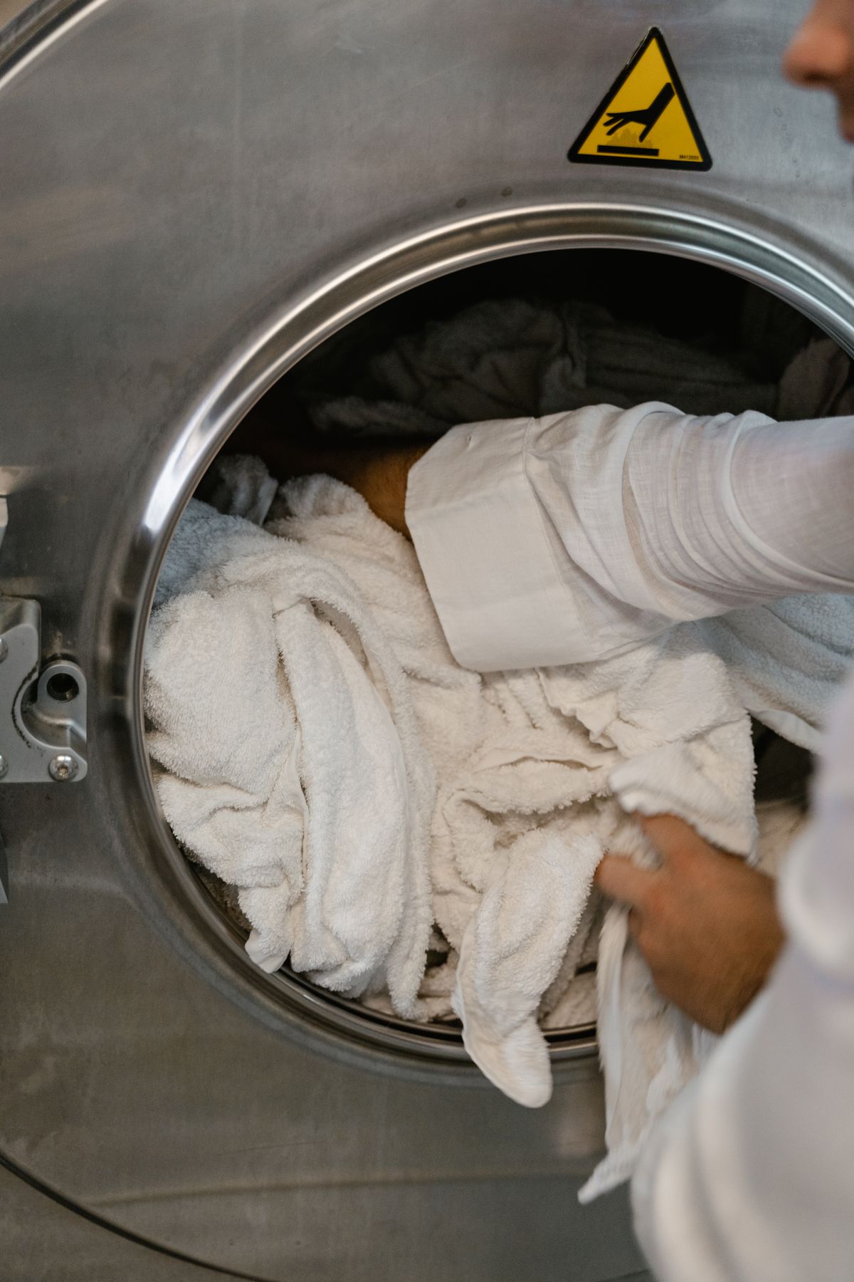 Technician loading laundry into a professional washing machine